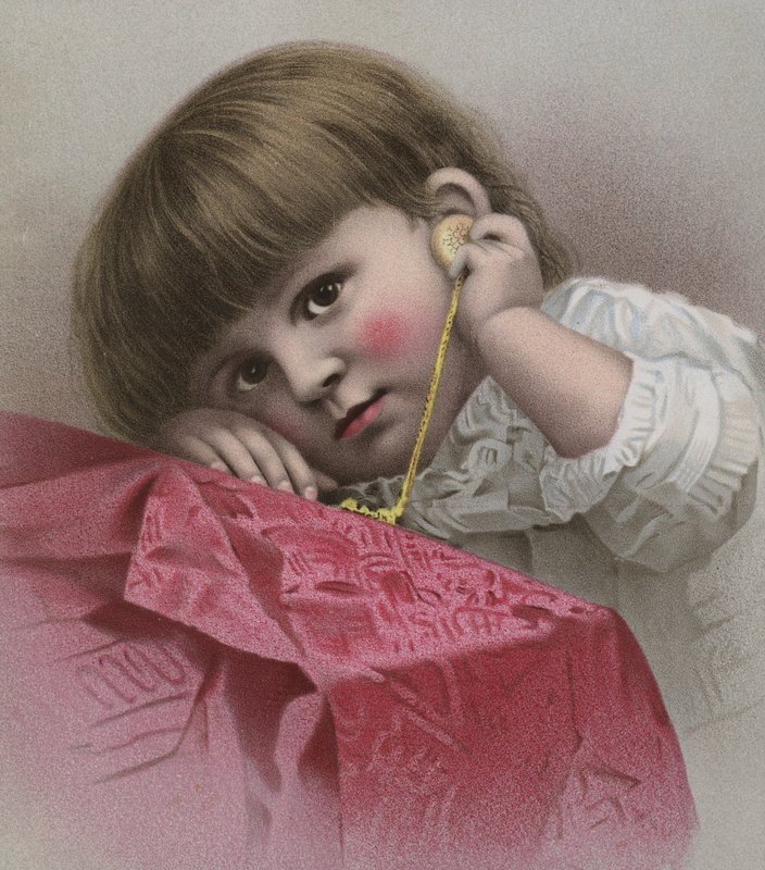 Criança de olhos castanhos e olhos grandes ouvindo o tique-taque de um relógio de ouro de European School