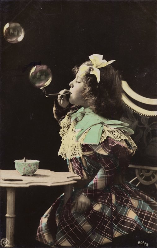 Uma menina soprando bolhas de um cano (foto matizada) de French Photographer