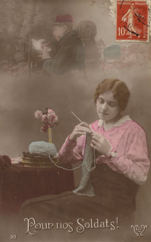 Uma jovem tricota enquanto pensa em seu soldado que está escrevendo uma carta para casa (foto colorida) de French Photographer