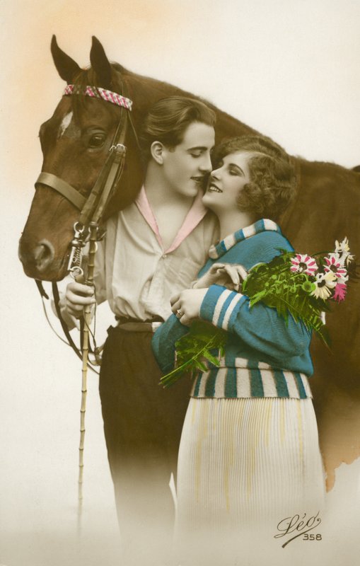 Casal prestes a beijar, de pé junto ao cavalo castanho (foto a cores) de French Photographer