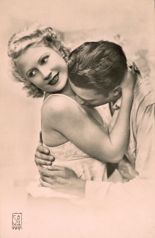 Homem abraça mulher e beija-lhe o peito (fotografia a preto e branco) de French Photographer