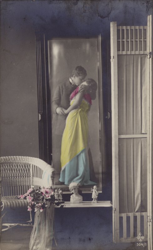 O reflexo em um espelho de um jovem casal se beijando (foto matizada) de French Photographer