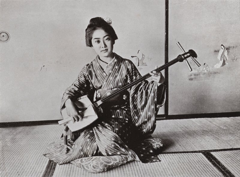 Uma gueixa tocando o Samisen (foto a p/b) de Herbert Ponting