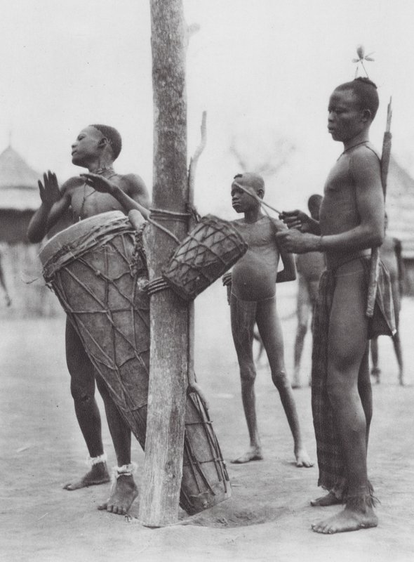 África: Homens Moru a tocar tambores (fotografia a preto e branco) de Hugo Adolf Bernatzik