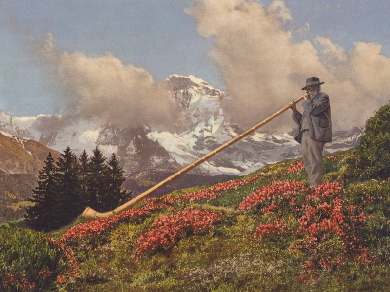 Suíça: Um Alphorn Blower, o Jungfrau no fundo (foto a cores) de Jean Gaberell
