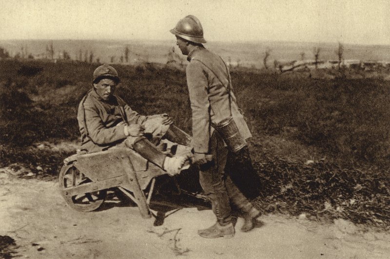 Soldado francês capturado a transportar o seu camarada ferido num carrinho de mão, na Primeira Guerra Mundial. de Photographer German