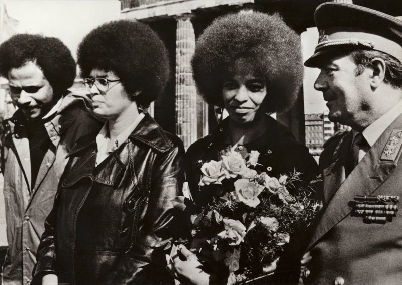 Em 11 de Setembro de 1972, a corajosa defensora americana dos direitos civis e comunistas Angela Davis foi cordialmente recebida pelos soldados do Exército Nacional Popular da República Democrática Alemã no Portão de Brandenburgo (foto a p/b). de Photographer German