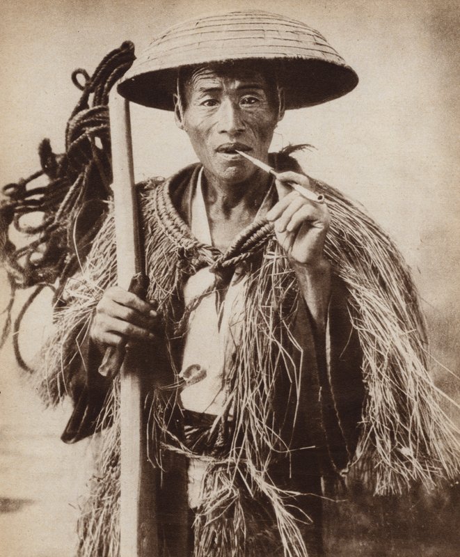 Geleira japonesa (trabalhador agrícola) usando um chapéu para protegê-lo da chuva forte nos campos de arroz (foto a p/b) de Photographer Japanese
