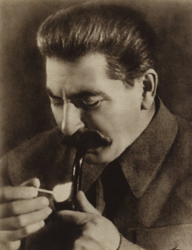 O líder soviético Joseph Stalin acende seu cachimbo, 1936 de Russian Photographer