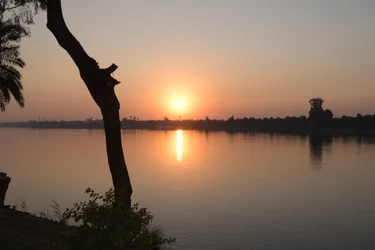 Reflexos do pôr-do-sol dourado num rio tranquilo