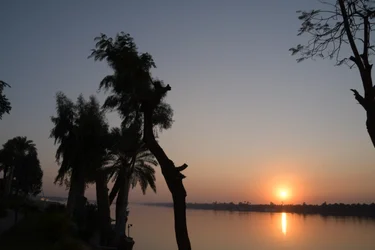 Reflexos do pôr-do-sol dourado num rio tranquilo
