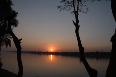 Reflexos do pôr-do-sol dourado num rio tranquilo
