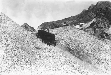 Transporte de um enorme comboio de mármore ao longo de uma estrada perto de uma pedreira nos Alpes Apuanos, Toscana