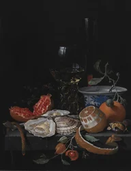 Ostras, frutas e um copo de vinho em uma mesa de pedra