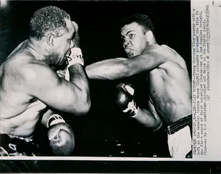 O jovem Cassius Clay acerta com a esquerda no veterano Archie Moore no primeiro assalto do combate em Los Angeles