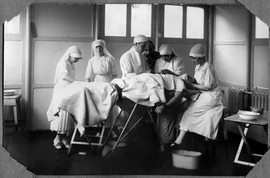 Primeira Guerra Mundial 1914-1918: médicos e enfermeiros da Cruz Vermelha (Therese Pavillou? ) tratando um soldado que dormia em clorofórmio no campo de Couville, na Manche, Basse-Normandie (Baixa Normandia), França. Fotografia anónima