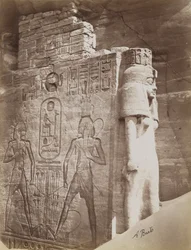 Rainha no Templo de Abu Simbel, vista de detalhe do trono e rainha abaixo do Colosso sentado de Ramesses II, no lado norte da entrada do Templo do Sul
