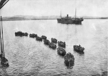 Tropas australianas sendo rebocadas em terra em isqueiros para pousar em Anzac Cove, Gallipoli. No fundo é o navio de transporte, 1915