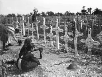 Crianças francesas cuidando de sepulturas em Adelaide Cemetery de australianos mortos em batalha no front ocidental, Villers-Bretonneux, França 26 de agosto de 1919