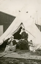 Irmã Eleanor Wibmer Jeffries e Irmã Nellie Constance Morrice (à direita) do lado de fora de sua tenda no número 3 do Hospital Geral Australiano com flores colhidas na margem do Somme, c. Junho de 1917 (foto do bw