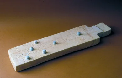 Tabuleiro de jogo com peças de jogo, de Tell Beit Mirsim, Jordânia, c.2000-1700 aC (calcário)