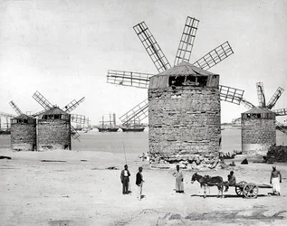 Moinhos de vento no Mar Mediterrâneo em Alexandria, Egito. Em frente, alguns egípcios posando com uma pequena carroça