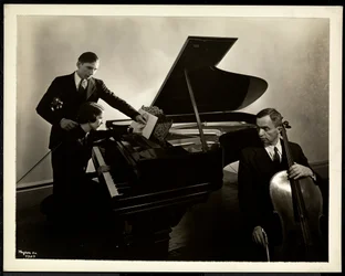 Mulher cega, Miss Harding, ao piano instruindo dois cegos no violino e violoncelo, 1936 (impressão de gelatina de prata)