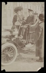Hattie Williams sentada com o motorista em um dos primeiros automóveis de Nova York, Nova York, 1890-1910 (impressão de gelatina de prata)
