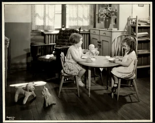 Duas meninas cegas com deficiência visual comendo em uma pequena mesa com boneca na Associação Nova Iorque para os Cegos, 111 East 59th Street, Nova York, 1933 (impressão em gelatina de prata)