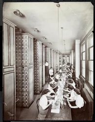 Mulheres trabalhando em uma sala de arquivo, sob supervisão masculina, no Metropolitan Life Insurance Co. na 23rd Street e Madison Avenue, 1907 (impressão em gelatina de prata)