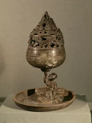 Incensário na forma da montanha cósmica &39;po-shan-lu&39; sustentada por um homem sentado em um monstro, da Tumba da Princesa Tou Wen, Mancheng, Hebei, Dinastia Han Ocidental (bronze)