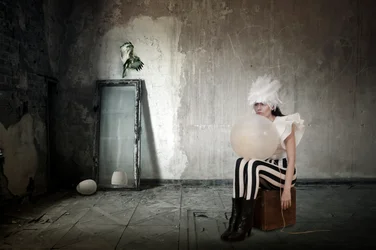 Mulher com penas e um balão