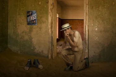 Homem num quarto abandonado