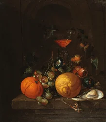 Um limão, uma laranja, uvas, uma ostra e um copo de vinho em uma borda