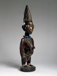 Figura gêmea (ere ibeji), região de Ila-Orangun, Nigéria, final do século 19 ou início do século 20 (madeira, contas de vidro e vestígios de tukula)