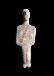 Ídolo masculino, figura esquemática. Escultura em mármore branco com incrustações ocres, 3200-2000 a.C.