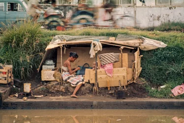 Cabana de cartão, junto a um canal de esgotos, serve de casa. Jacarta, Indonésia.
