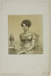 Mulher sentada diante de uma mesa