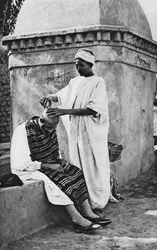 Um barbeiro de rua e seu cliente, Argélia, África, 1922.