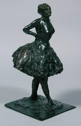 Dançarina de vestido casual, as mãos nos quadris, a perna direita para a frente, fundida c.1919-21