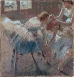Três bailarinas a preparar-se para a aula