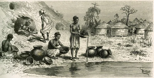 Mulheres na aldeia de Koumakhana lavam ouro, ao fundo, homens procuram ouro em galerias subterrâneas. Gravura de Riou, para ilustrar a história "Exploration du Haut-Niger (Haut-Niger)" (actual Mali) do Comandante Joseph Gallieni (1849-1916) da