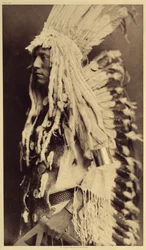 Pessoa idosa, Piegan. Os jovens não perdem nenhuma ocasião de festas públicas para vestirem as roupas do seu pai guerreiro. Foto tirada do volume 6 da enciclopédia publicada por Edward S. Curtis (1868-1952) sobre os índios da América do Norte, com um desta
