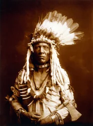 Cauda de Doninha, Piegan, com um Tomahawk, c. 1900, foto Edward S. Curtis