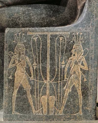 Grupo escultórico em granito com Horemheb a fazer oferendas ao deus Atum, pormenor do trono de Atum com Seth e Hórus
