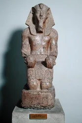 Estátua ajoelhada de Amenófis II (1427-1392 a.C.) segurando oferendas de vinho, de Tebas, Império Novo, c. 1450-1425 a.C. (granito)