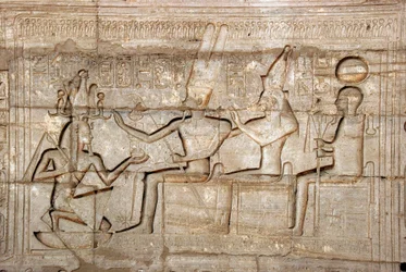 Antiguidade egípcia: relevo representando o Faraó Ramsés II diante das divindades da tríade Theban, Amon, Mut e Khonsu; Templo funerário dedicado ao Faraó Ramsés II (1279-1213 a.C.), local de Ramasseum (Ramesseum) em Luxor, Egito.