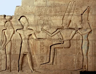 Antiguidade egípcia: relevo representando o faraó Ramsés II diante de duas divindades da tríade tebana, Amon e Mut; templo funerário dedicado ao faraó Ramsés II (1279-1213 a.C.), sítio do Ramesseum em Luxor, Egito.