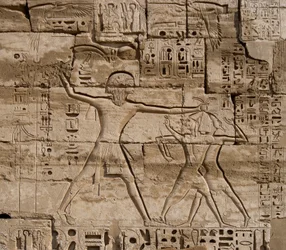 Antiquidade egípcia: detalhe de relevos celebrando as vitórias do faraó sobre os povos do mar. Templo Funerário de Ramsés III (1187-1156 AC). Luxor, Medinet Habou, Egito