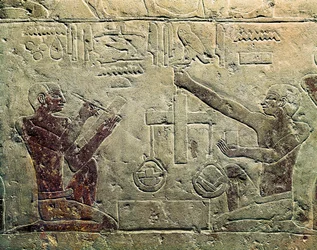 Alívio básico representando um comerciante e um cliente: um dos números usa uma escala enquanto o outro toma notas, c.2465-2323 BC